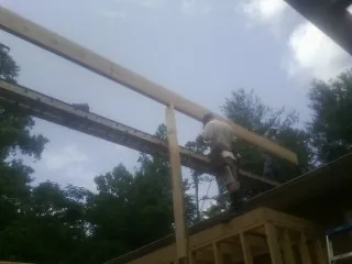 Carpenter setting a ridge beam over a new addition frame — Ice Dam Removal by Roofing Brothers in West Wardsboro