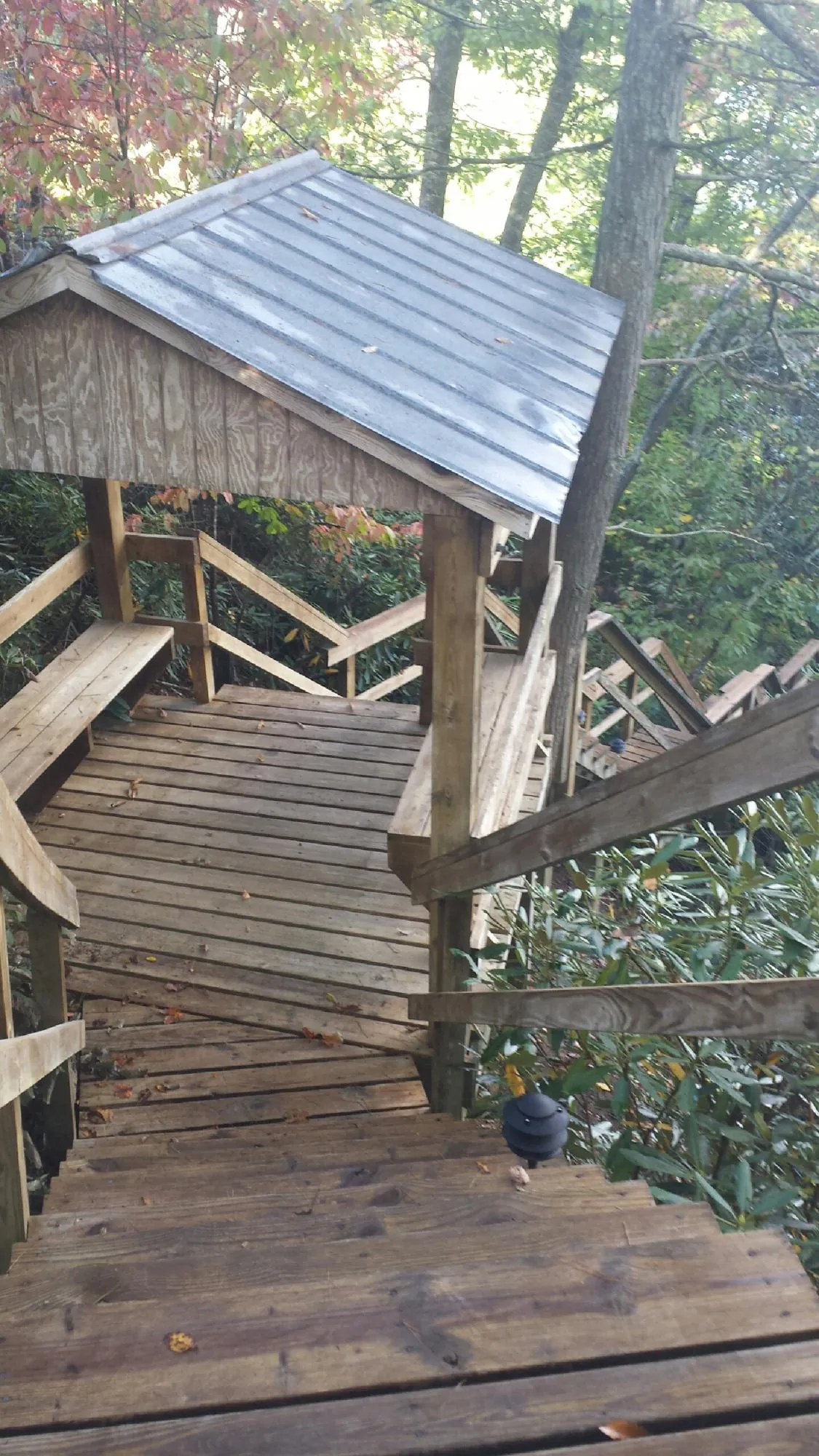 Metal roofed shelter over wooden steps on a wooded walkway — Skylight Repair & Installation work by our crew in West Wardsboro