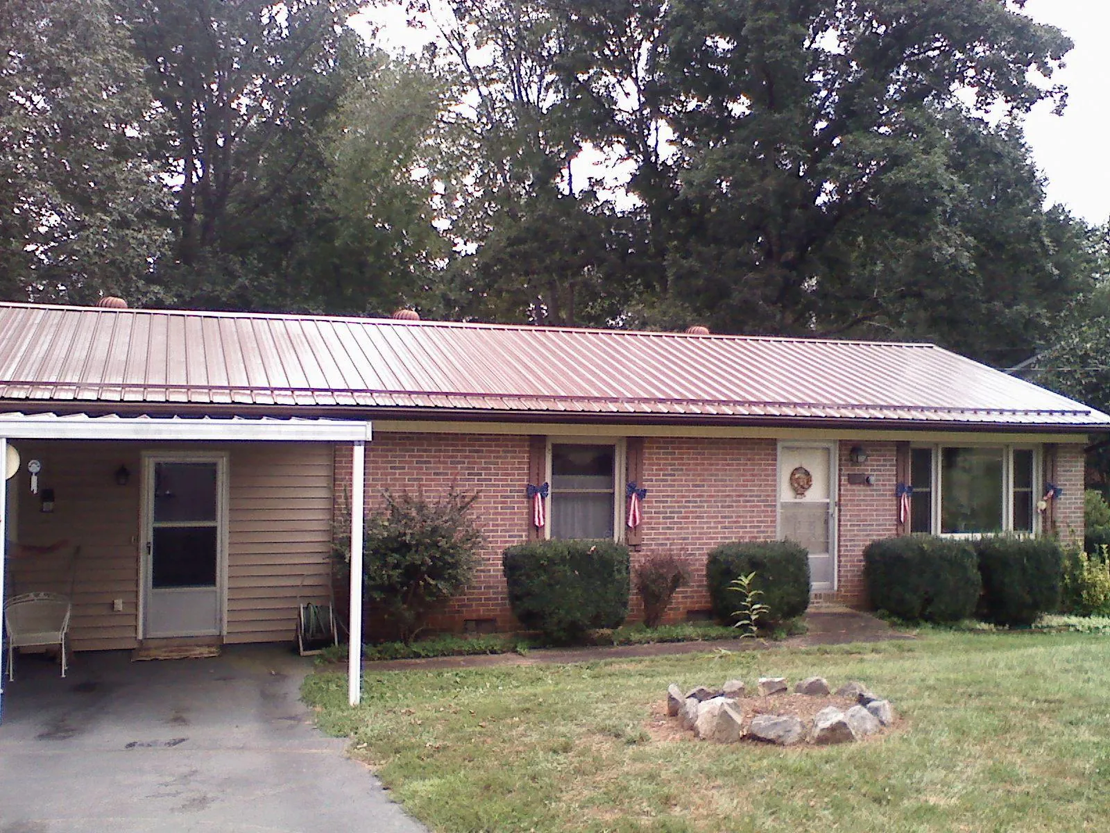 Bronze metal roof and carport on a brick ranch home — Roof Repair work by our crew in West Wardsboro